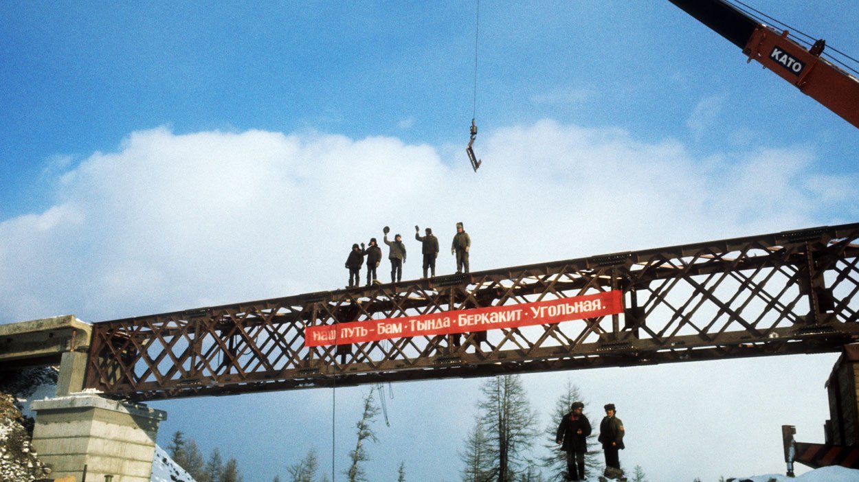 В 1974 началась стройка века железная. БАМ стройка века. Амурский мост стройка СССР. Советские стелы строителям БАМА. Долгострой БАМ.